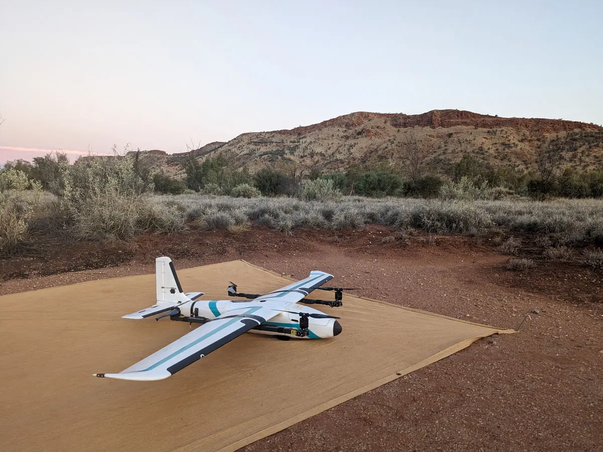 Fixed-wing drone on launch mat preparing for photogrammetry survey in remote terrain